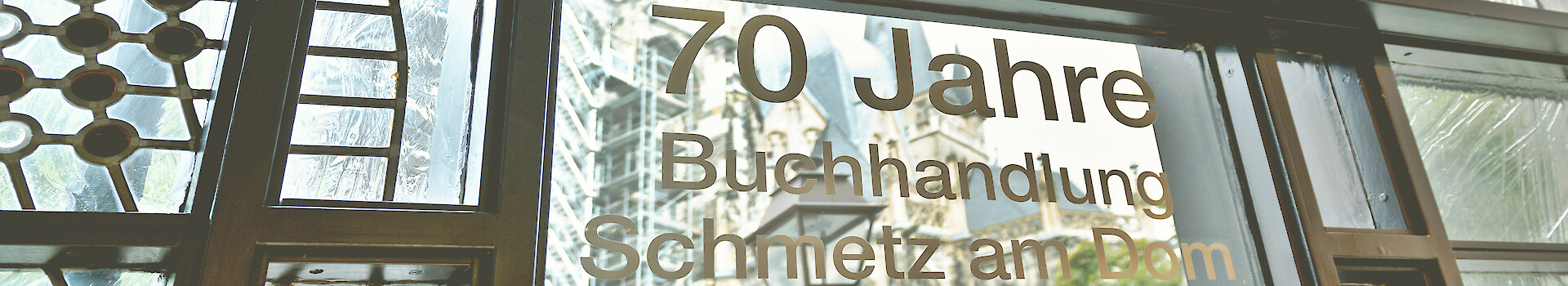 buchhandlung-schmetz--heroimage--about_us-mirrored Buchhandlung Schmetz am Dom, Aachen: Blick durch ein Schaufenster